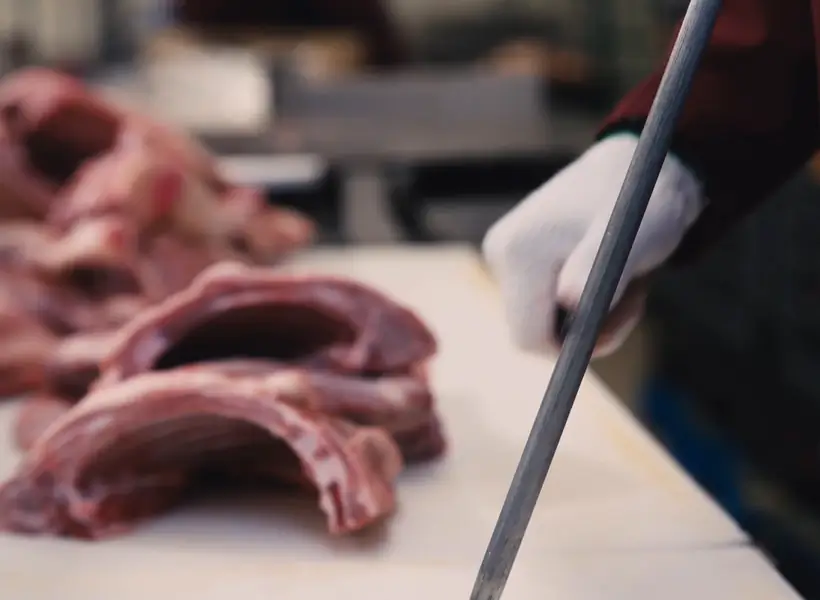 Un boucher Iasenza prépare des côtes d'agneau