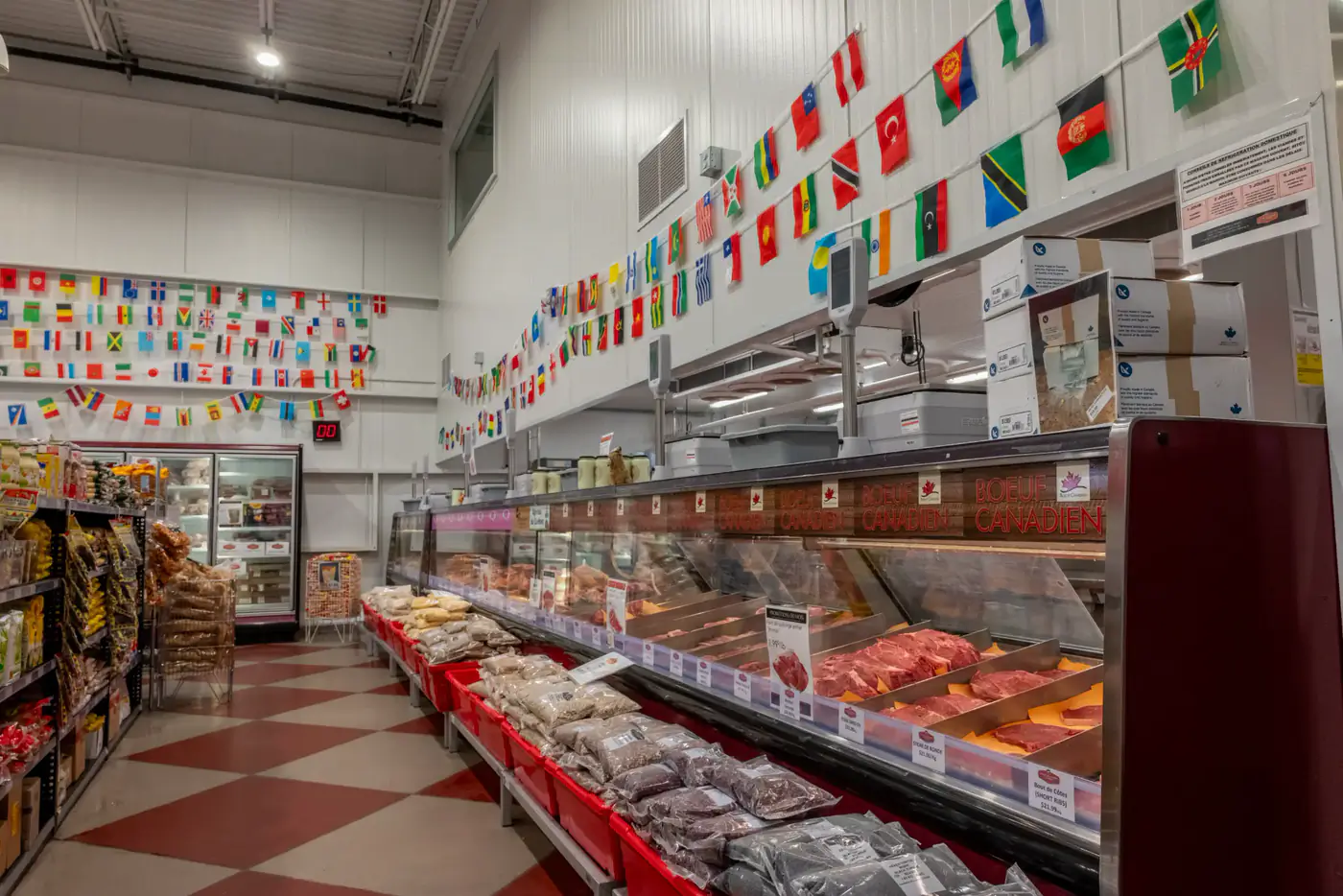 Comptoir de viandes sous une rangée de drapeaux du monde à la succursale Dollard-des-Ormeaux