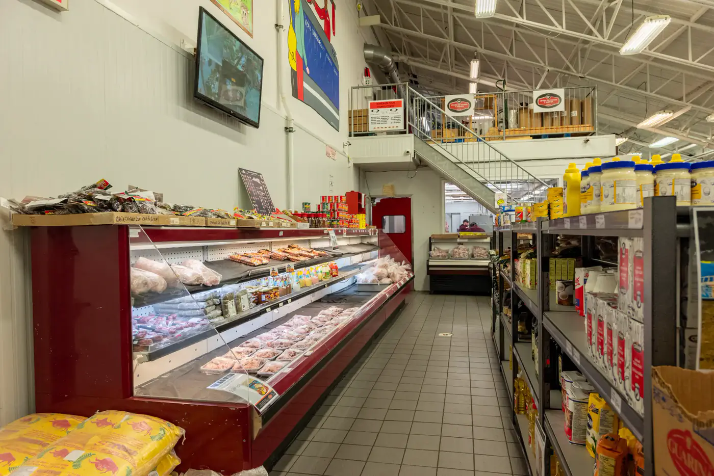 Allée entre un comptoir réfrigéré et des rayons d'épicerie à la succursale Laval