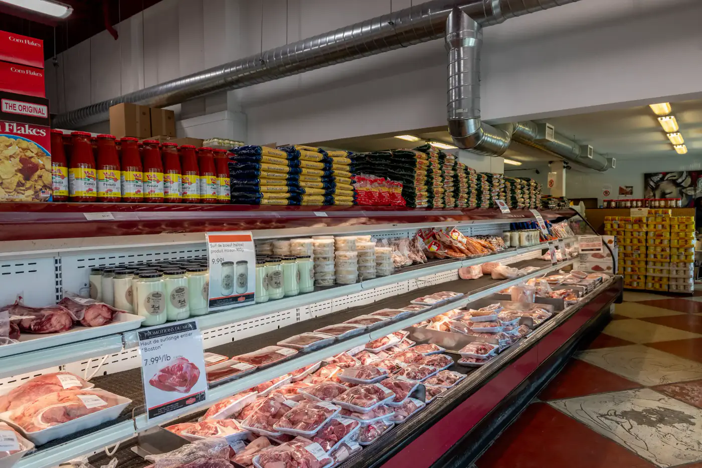 Comptoir réfrigéré de viandes emballées sous des rayons d'épicerie à la succursale Longueuil
