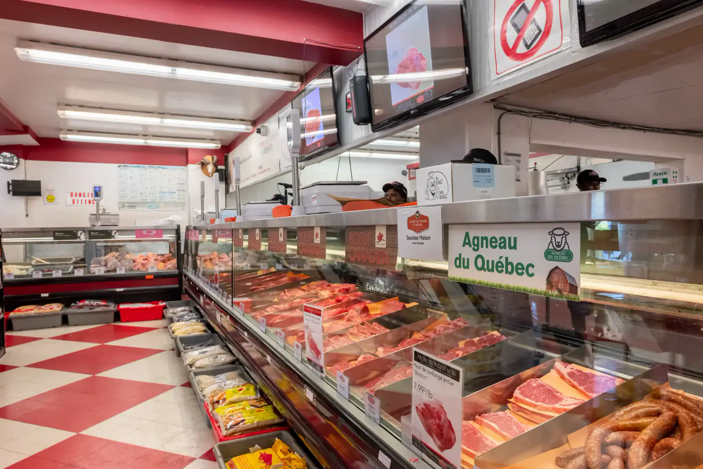 Allée le long du comptoir de viandes, plancher en damier rouge et blanc, à la succursale Montréal-Nord