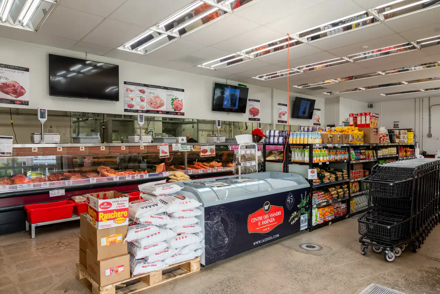 Intérieur de la succursale Tétreaultville avec le comptoir de viandes, un congélateur et des rayons d'épicerie